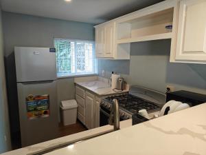 a small kitchen with a stove and a refrigerator at The Cozy Flat by UWI in Hope Pastures +22 photos