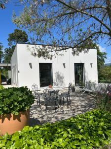 a patio with a table and chairs in front of a building at La maison Jane domaine d'Aiguebonne in Allex