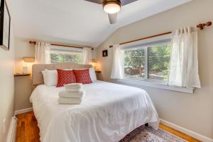 una camera da letto con un letto bianco con una finestra di Private Hot Tub - Riverfront Cabin In Estes Park! a Estes Park