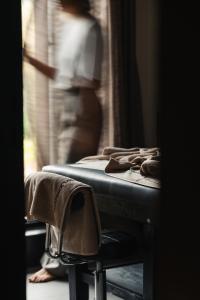 a bed in a room with a person looking out the window at Silverback Lodge in Buhoma +32 photos