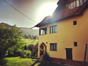 a large yellow house with a view of a field at Pensiunea La Muncel in Sadova