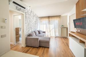 Una sala de estar con un sofá y una ventana grande. en Suite della Rovere, en Alba