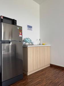 a kitchen with a stainless steel refrigerator and a sink at K Avenue High Floor Studio Balcony with Sunrise View in Kota Kinabalu
