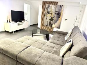 a living room with a couch and a television at Stilvolles Designappartment mit Terasse & Garten im idylischem Bindlach in Bindlach