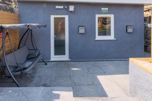 a blue building with a chair and a door at Private & Relaxed Apartments 1-5 in Cardiff