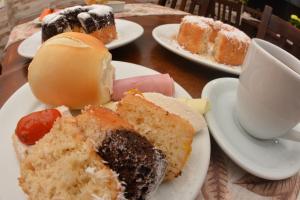a table with plates of pastries and a cup of coffee at FLAT HShotelaria in Florianópolis