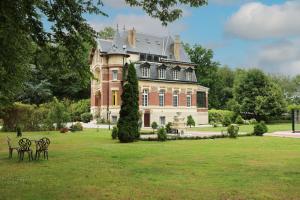a large house with two chairs in the grass at Château de Moliens in Moliens