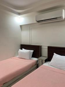 a room with two beds with pink sheets and a fan at AL ASAFRA DAHAB - families only in Alexandria +42 photos