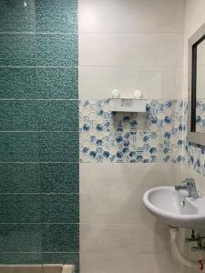 a bathroom with a sink and blue and white tiles at AL ASAFRA DAHAB - families only in Alexandria +42 photos