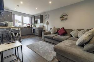 a living room with a couch and a kitchen at The Loft - 3 bedroom in Crieff in Crieff