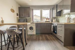 a kitchen with a counter and some stools in it at The Loft - 3 bedroom in Crieff in Crieff +4 photos