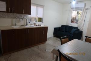 a kitchen and a living room with a blue couch at אחוזת ישוב הדעת in Safed