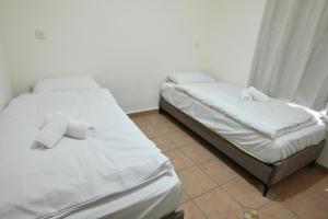 two beds in a room with white sheets and towels at אחוזת ישוב הדעת in Safed