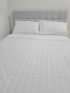 a white bed with white sheets and pillows at Kuya Os Staycation at Royal Oceancrest Condominium Panglao in Dauis +17 photos