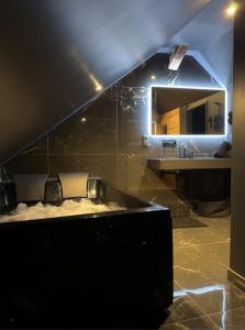 a bathroom with a sink and a mirror at BlackRoom - Balnéo - Ciel étoilé in Belfort +20 photos