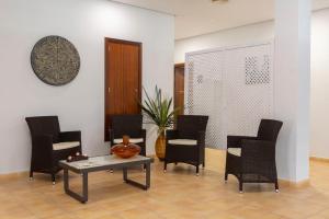 a living room with chairs and a table and a table at Hipotels Barrosa Garden in Chiclana de la Frontera