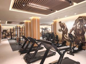 a gym with cardio equipment and a painting of a man at Hipotels Barrosa Garden in Chiclana de la Frontera
