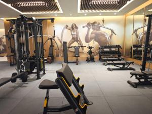 a gym with lots of equipment and a painting of women at Hipotels Barrosa Garden in Chiclana de la Frontera