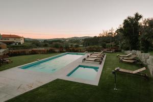 a swimming pool with lounge chairs at Vila Coura in Amarante