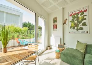 a living room with a green couch and a table at La Quinta Bordeaux-Bègles in Bègles +17 photos