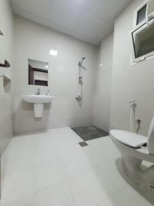 a white bathroom with a sink and a toilet at اجنحه اسوار للشقق الفندقيه in Salalah
