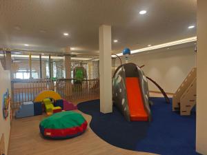 a childrens play room with a slide and play equipment at Hipotels Barrosa Garden in Chiclana de la Frontera