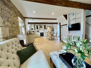 a living room with a couch and a kitchen at Rutland Cottage, Ketton, Stamford by Belmont Places in Ketton