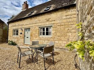 a table and chairs in front of a brick building at Rutland Cottage, Ketton, Stamford by Belmont Places in Ketton