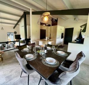 ein Esstisch und Stühle in einem Wohnzimmer in der Unterkunft Magnifique Villa en Dordogne Piscine chauffée in Saint-Aulaye