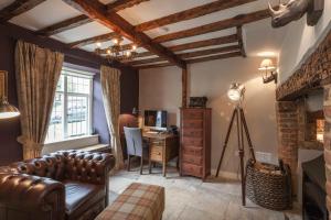 ein Wohnzimmer mit Couch und Schreibtisch in der Unterkunft Three Little Pigs Luxury Cottage in Milton Abbas