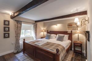 a bedroom with a large bed and a window at Three Little Pigs Luxury Cottage in Milton Abbas