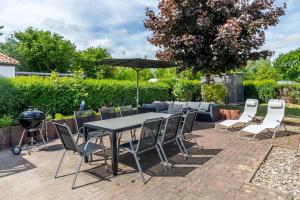 a table and chairs with an umbrella and a grill at Ferienhaus Meerblick in Wohlenberg