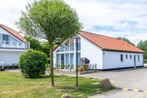 a tree in front of a white house at Ferienhaus Meerblick in Wohlenberg +38 photos
