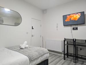 a bedroom with a bed and a tv on the wall at Private & Relaxed Apartments 1-5 in Cardiff