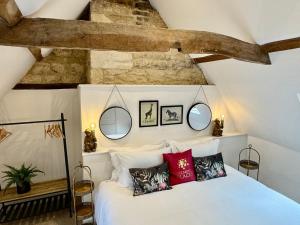 a bedroom with a white bed with red pillows at Rutland Cottage, Ketton, Stamford by Belmont Places in Ketton