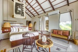 1 dormitorio con cama extragrande y sofá en Mia Tulum Beachfront Resort - Ocean View Suites and Beach Club, en Tulum