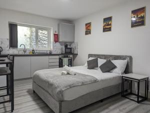 a bedroom with a large bed and a kitchen at Private & Relaxed Apartments 1-5 in Cardiff