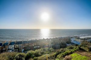 HollingtonSeascape - 2 bedroom flat with panoramic sea views的阳光下的海边建筑群