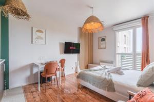 a bedroom with a bed and a table and a desk at Le Tahiti, 2 pers, 10 min Disneyland Paris in Marne-la-Vallée +15 photos