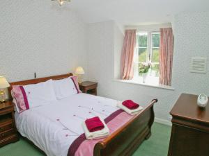 a bedroom with a bed with two towels on it at Bickley School House in Broxa