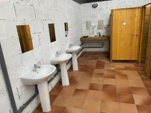 a bathroom with three sinks and two mirrors at Glamping Calvados in Cauville