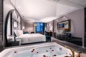 une chambre d'hôtel avec un lit et une baignoire dans l'établissement 青岛崂山石老人会展中心桔子水晶酒店, à Qingdao 2 autres photos