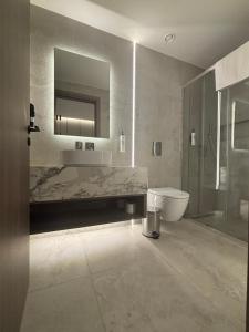 a bathroom with a sink and a toilet and a mirror at Tuck Inn in Larnaca
