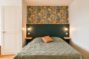 a bedroom with a bed with a green head board at La Margotte Fibre Terrasse in Voiron