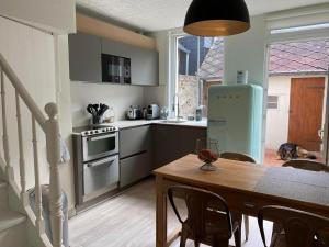 a kitchen with a table and a kitchen with a refrigerator at Ptit Somme en Baie in Saint-Valéry-sur-Somme +22 photos
