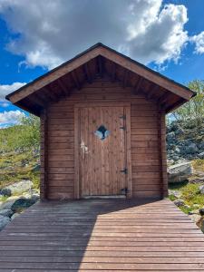 een houten hut met een grote houten deur bij Wilderness Hut Lake Tsahkal in Kilpisjärvi