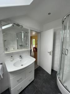 Un baño blanco con lavabo y ducha en Hotel Bevertal, en Beverungen