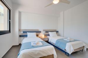 a bedroom with two beds with towels on them at Makenzy Star 2bd duplex 300m from beach in Larnaca +14 photos