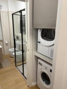 a bathroom with a washing machine and a microwave at Masonber trastevere centro Wi-Fi free balcone metro in Rome +44 photos