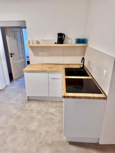 a kitchen with white cabinets and a stove top oven at Rybka living apartments in Přerov +10 photos